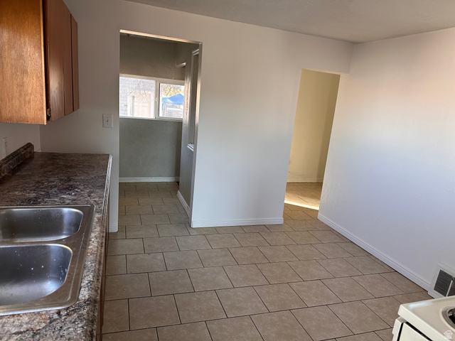 154 East Harris Street Ogden, UT 84401 - Photo 3 of 10 Kitchen featuring light tile patterned floors, dark countertops, and wood finish cabinets
