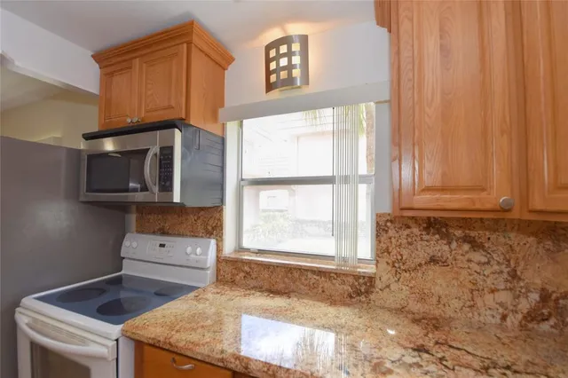 a kitchen with granite countertop cabinets stainless steel appliances and a sink