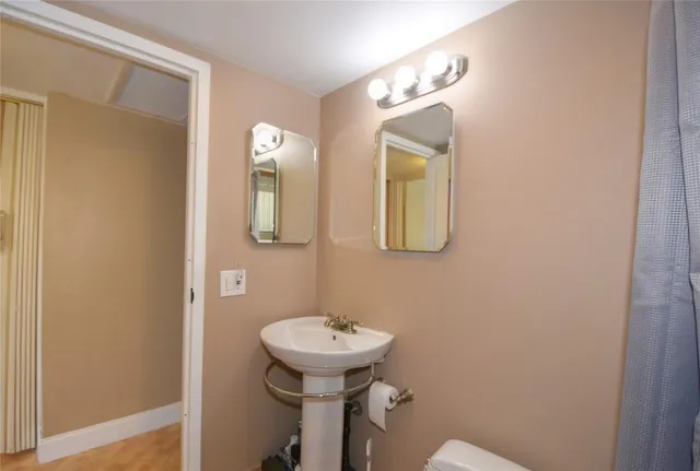 a bathroom with a toilet sink and mirror