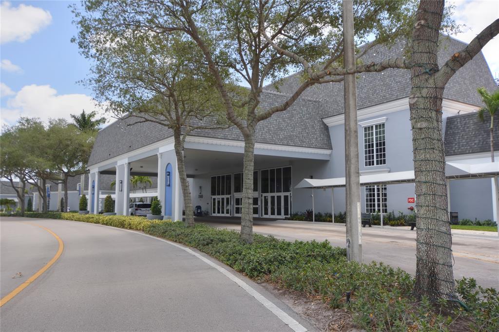 357 Saxony Lane, Unit 357 Delray Beach, FL 33446 - Photo 32 of 35 a front view of a house with garden and trees