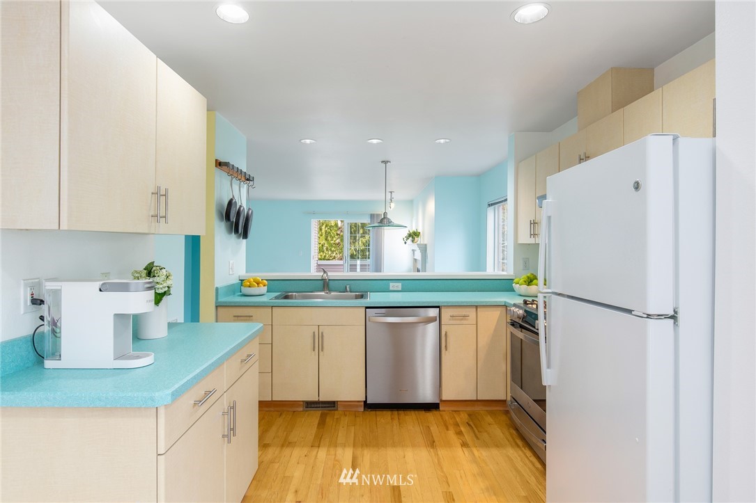 601 12th Avenue Northwest, Unit C 1 Issaquah, WA 98027 - Photo 4 of 17 a kitchen with a sink a refrigerator a window and white cabinets