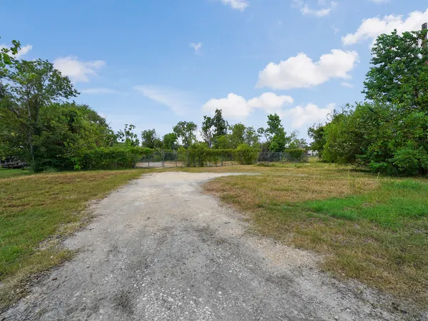 a view of a field with trees in background