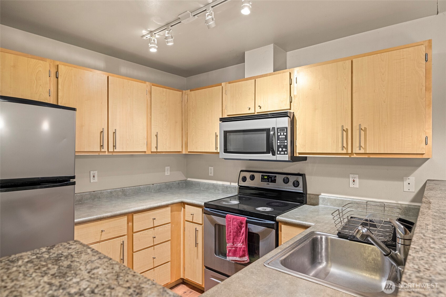 10709 Valley View Road, Unit B403 Bothell, WA 98011 - Photo 14 of 32 a kitchen with stainless steel appliances a stove sink microwave and cabinets