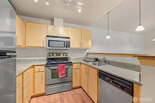 a kitchen with stainless steel appliances granite countertop a stove a sink and a microwave