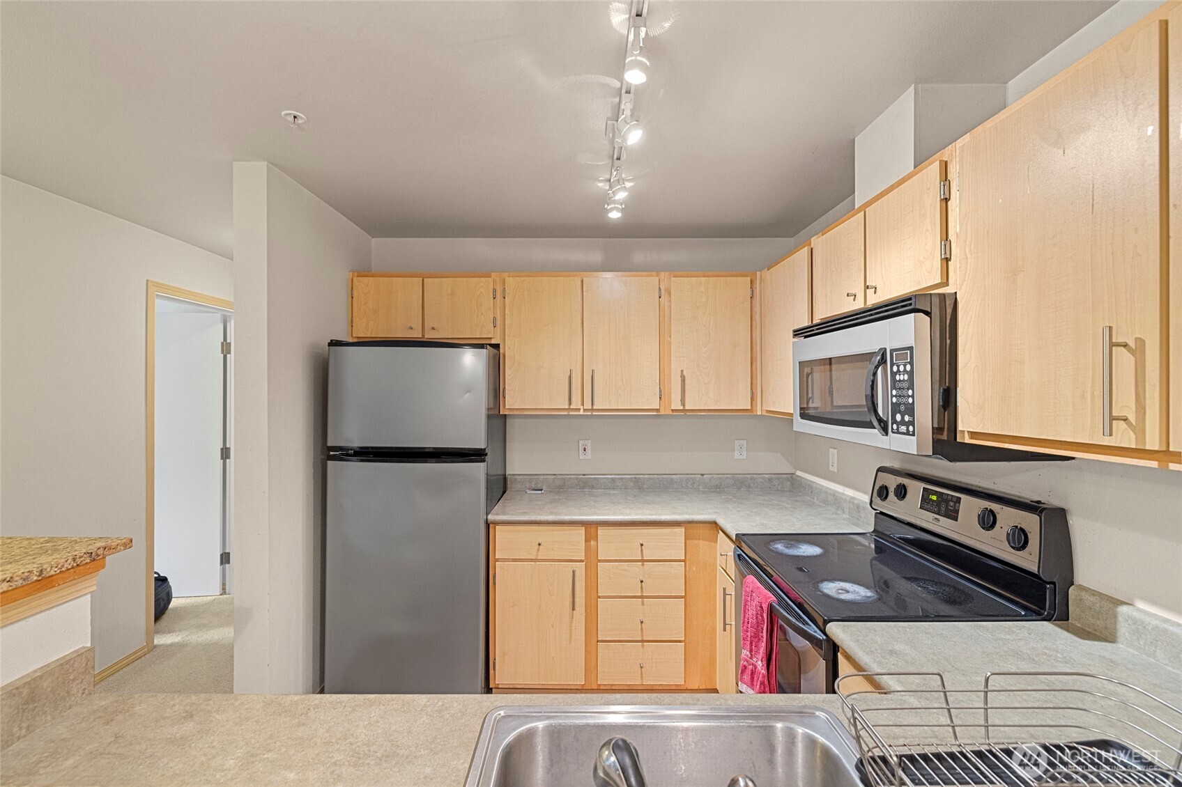 10709 Valley View Road, Unit B403 Bothell, WA 98011 - Photo 17 of 32 a kitchen with stainless steel appliances granite countertop a refrigerator a stove top oven a sink and dishwasher