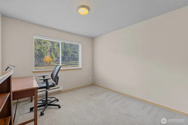 a view of a workspace with furniture and a window