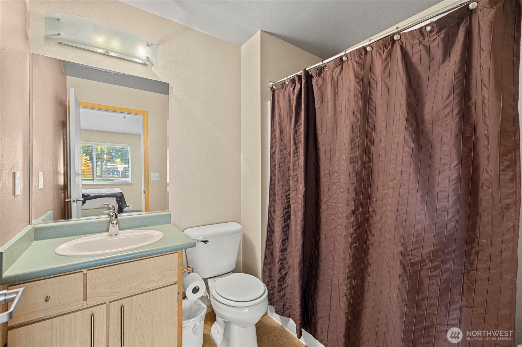 10709 Valley View Road, Unit B403 Bothell, WA 98011 - Photo 25 of 32 a bathroom with a toilet a sink and a mirror