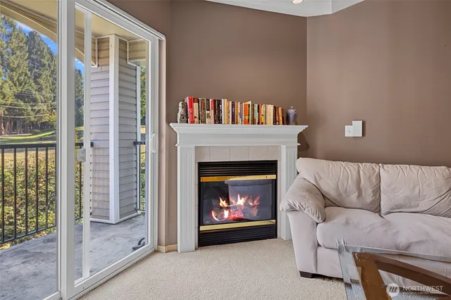 a living room with furniture a fireplace and a large window