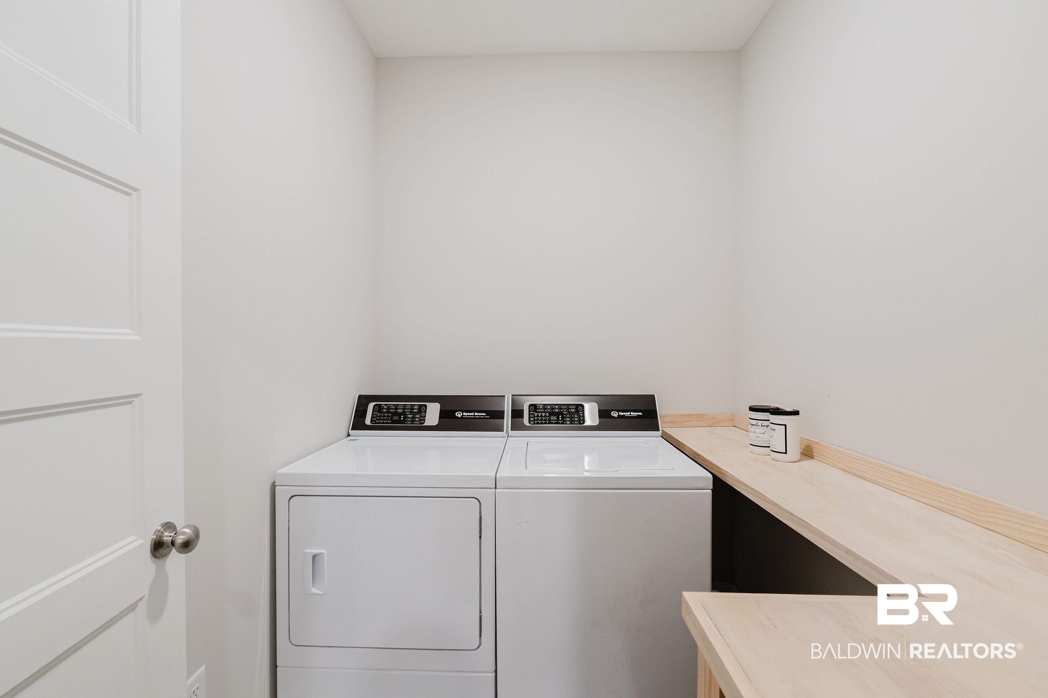 7872 Calverton Street Foley, AL 36535 - Photo 44 of 76 Dedicated laundry area featuring a light wood-finish countertop, white walls, and a solid panel door with a brushed nickel knob
