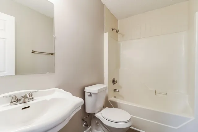 a white toilet sitting next to a bath tub
