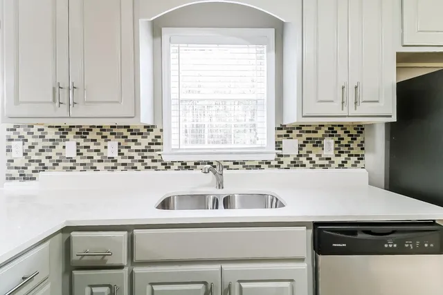 a close view of a sink and dishwasher with kitchen island