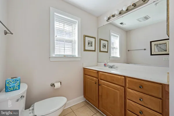 a bathroom with a granite countertop toilet sink and mirror