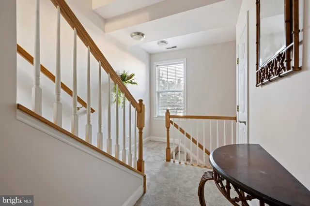 a view of staircase with wooden floor and a chandelier