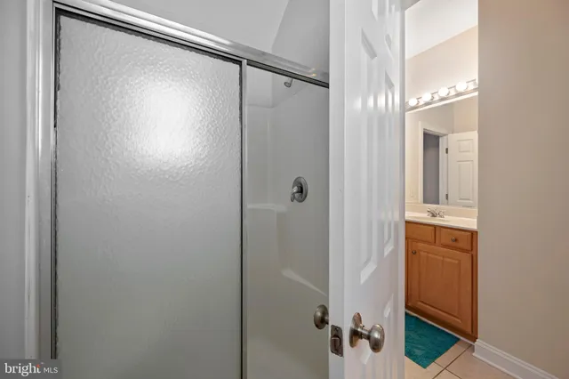 a bathroom with a glass shower door and a mirror