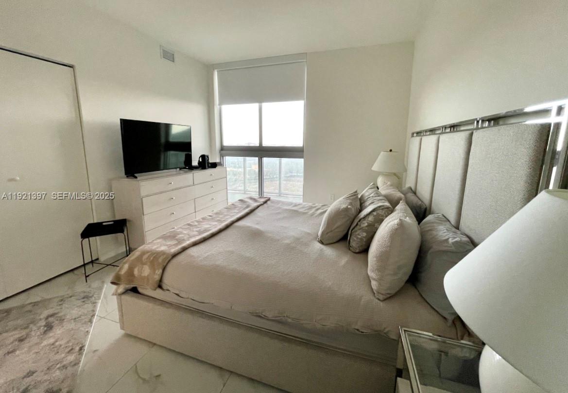 2000 Metropica Way, Unit 1009 Sunrise, FL 33323 - Photo 22 of 40 a bedroom with a bed and a flat screen tv