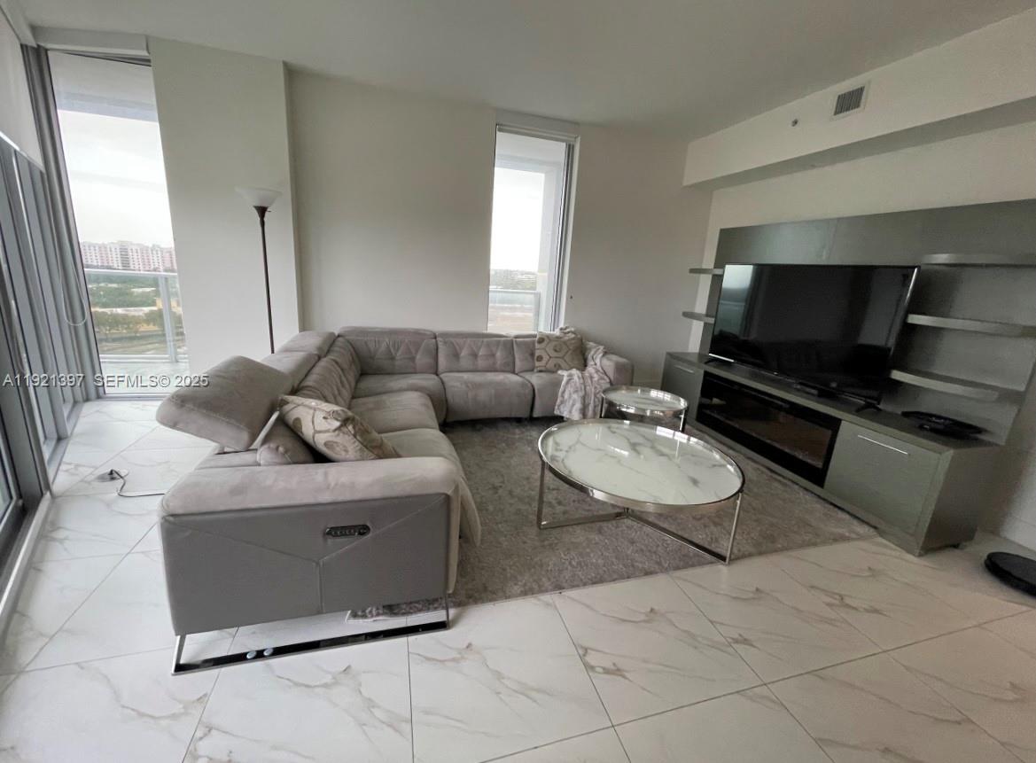 2000 Metropica Way, Unit 1009 Sunrise, FL 33323 - Photo 33 of 40 a living room with furniture and a flat screen tv