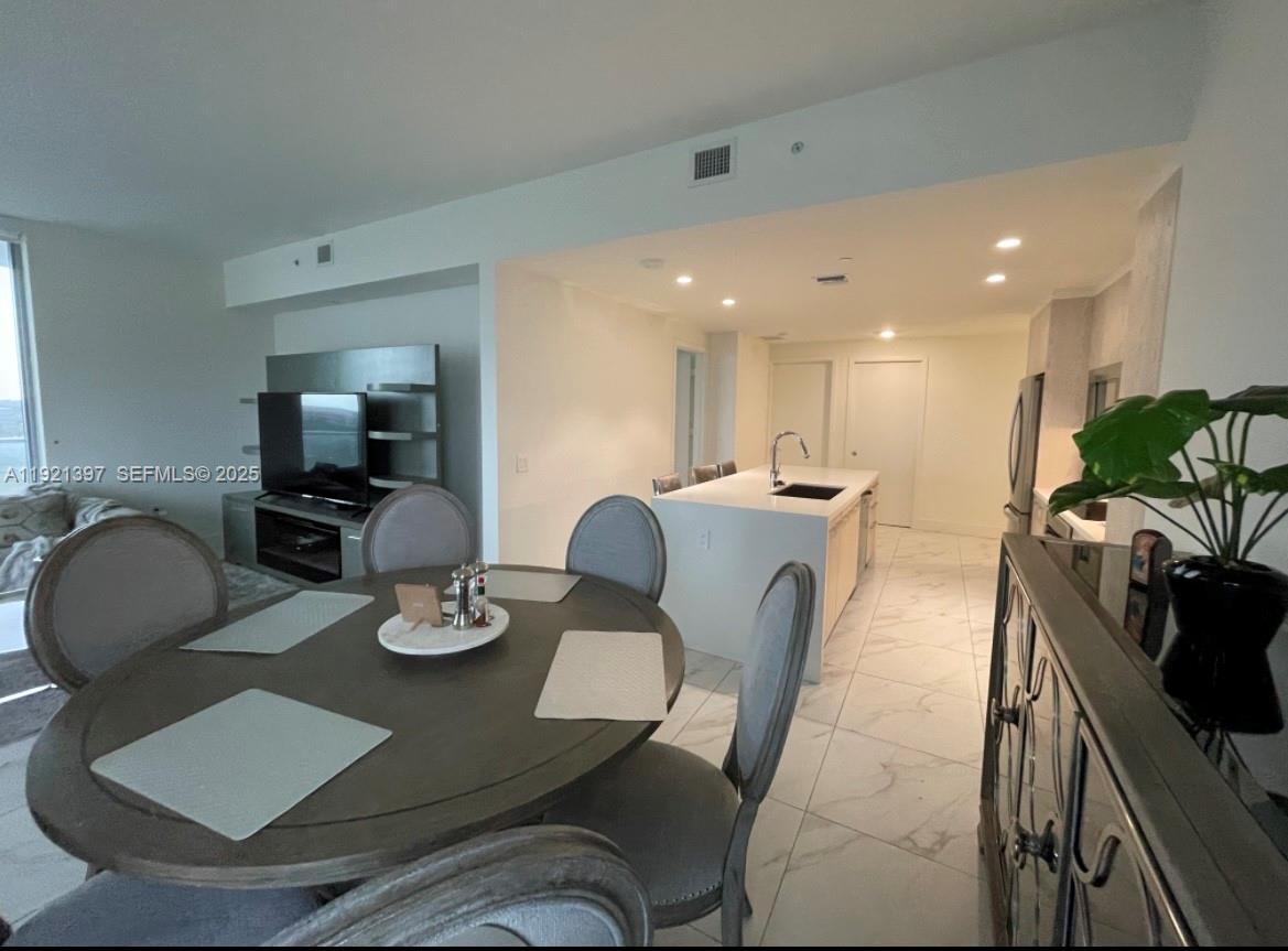 2000 Metropica Way, Unit 1009 Sunrise, FL 33323 - Photo 36 of 40 a dining room with furniture a wooden floor and a sink