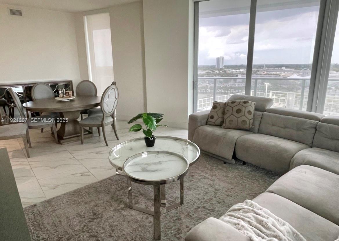 2000 Metropica Way, Unit 1009 Sunrise, FL 33323 - Photo 6 of 40 a living room with furniture and a large window