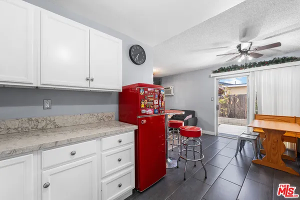 a kitchen with stainless steel appliances granite countertop a sink dishwasher stove and white cabinets with wooden floor