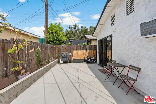 a view of a patio with table and chairs potted plants with wooden floor