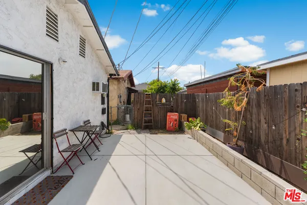 a view of a patio with table and chairs with wooden floor and fence