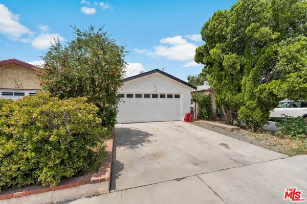 a view of garage with deck and garden