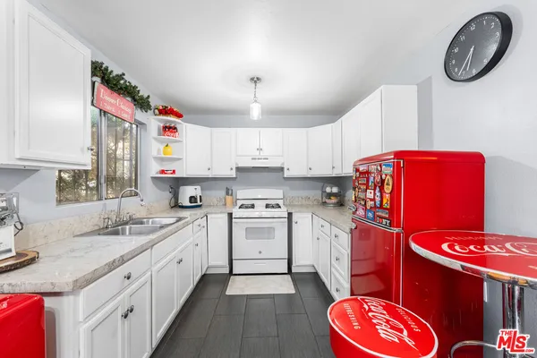 a kitchen with stainless steel appliances granite countertop a sink a stove and a refrigerator
