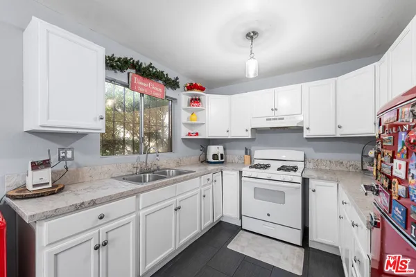 a kitchen with cabinets appliances a sink and a window