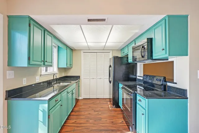 a kitchen with stainless steel appliances granite countertop a stove top oven a sink dishwasher and a refrigerator