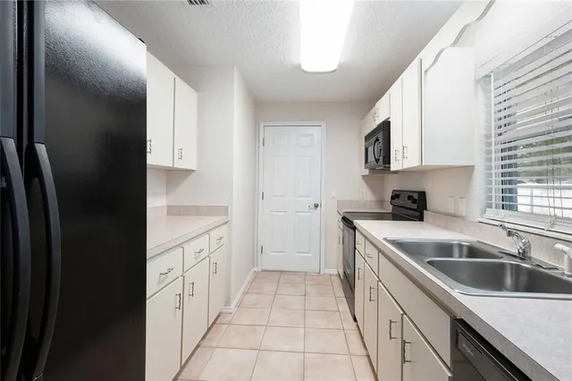 a kitchen with granite countertop a sink stove and refrigerator