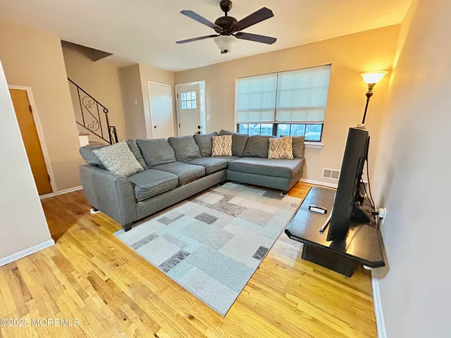 a living room with couches a flat screen tv and a dining table