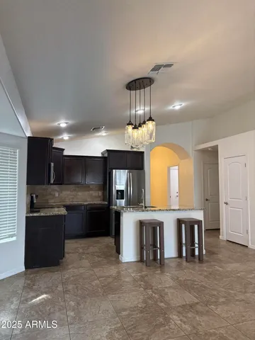 a large kitchen with stainless steel appliances granite countertop a stove and a refrigerator