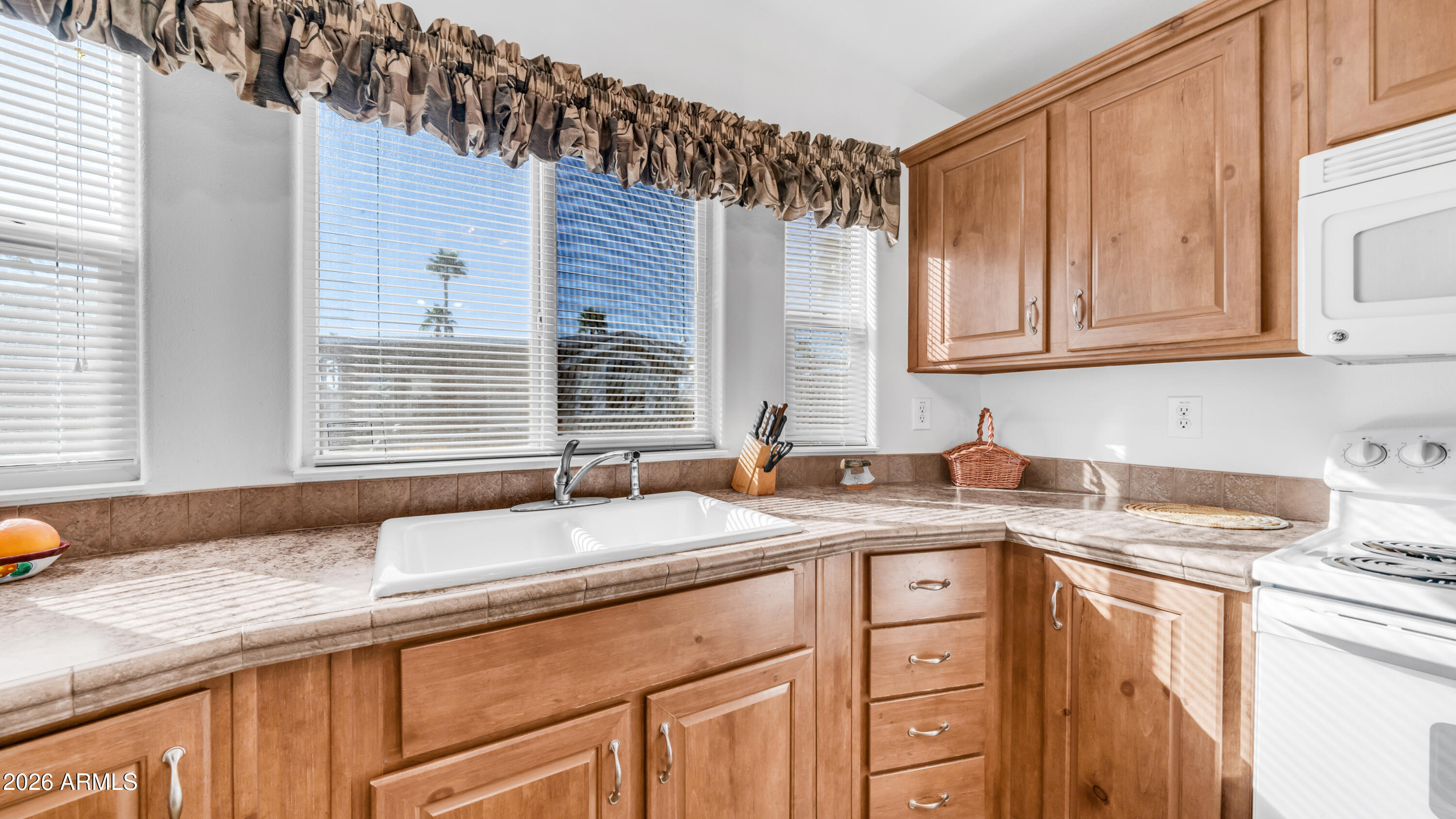 3710 South Goldfield Road, Unit 721 Apache Junction, AZ 85119 - Photo 11 of 63 a kitchen with granite countertop a sink and a white wooden cabinets