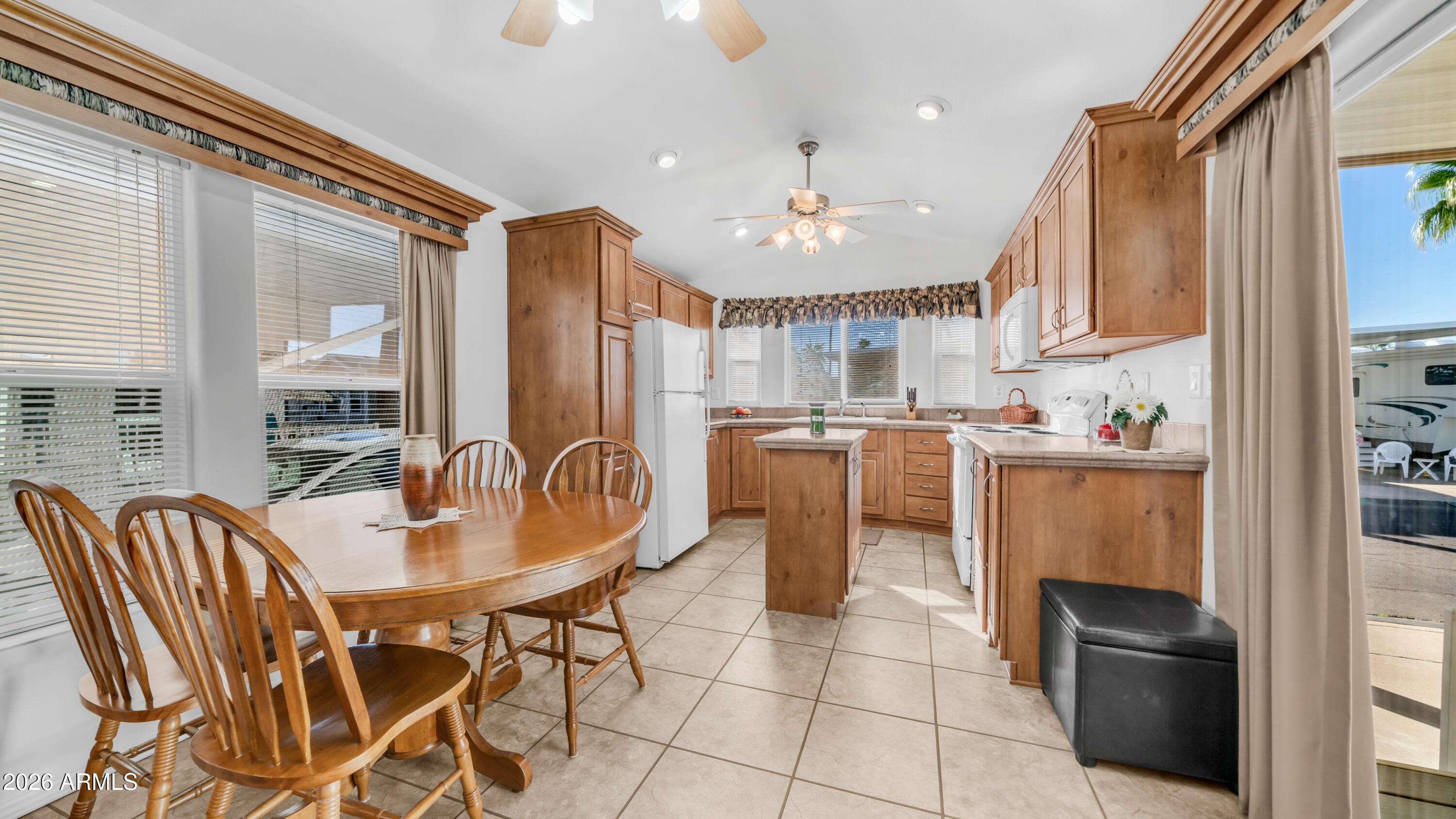 3710 South Goldfield Road, Unit 721 Apache Junction, AZ 85119 - Photo 6 of 63 a dining room with stainless steel appliances kitchen island granite countertop a refrigerator a stove a sink dishwasher and a dining table with wooden floor