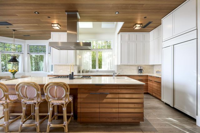 a kitchen with a table chairs sink refrigerator and cabinets