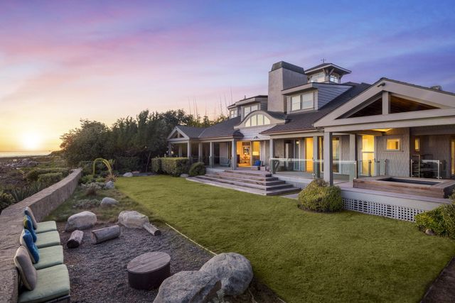 a view of a house with a yard and furniture