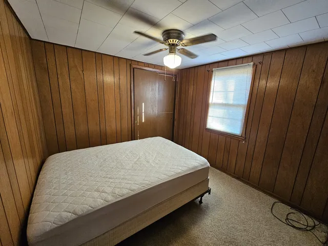 a bed sitting in a spacious bedroom next to a window