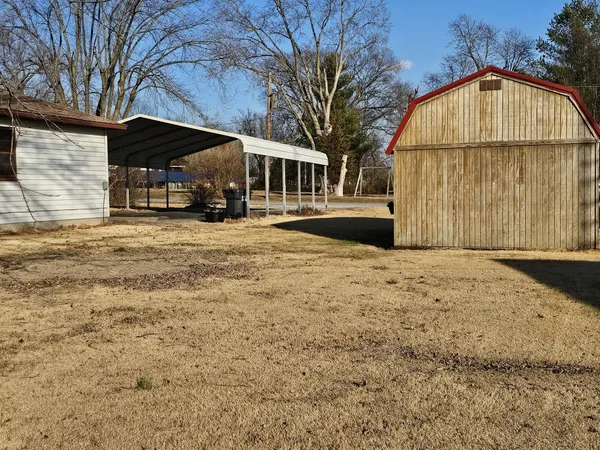 a view of house with backyard and trees