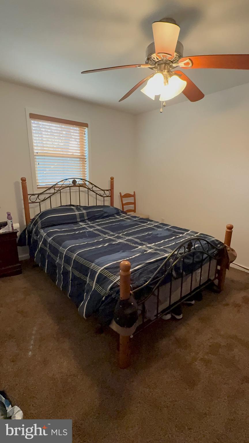 722 Oak Hill Road Berkeley Springs, WV 25411 - Photo 6 of 16 a bedroom with a bed and a chandelier