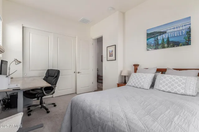 a bedroom with a bed a desk and chair