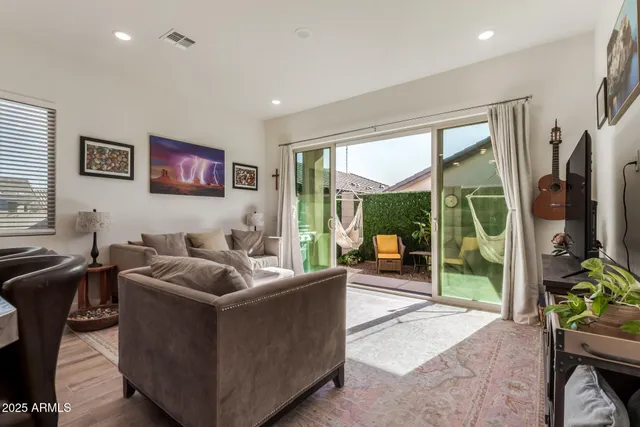 a living room with furniture a flat screen tv and a floor to ceiling window
