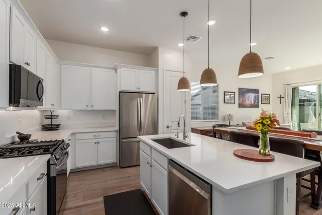a kitchen with stainless steel appliances granite countertop a sink a stove and a refrigerator