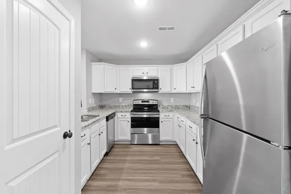 a kitchen with granite countertop a refrigerator stove and sink