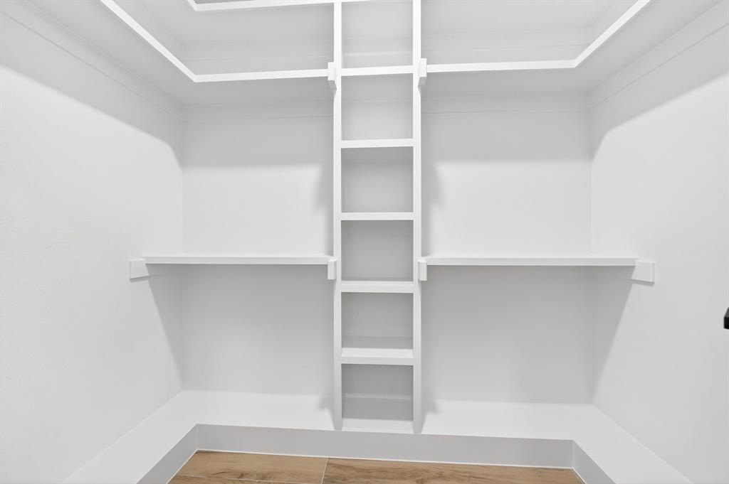 120 Springwood Road Enchanted Oaks, TX 75156 - Photo 28 of 37 Walk-in closet with built-in shelving, white walls, and wood-finish flooring