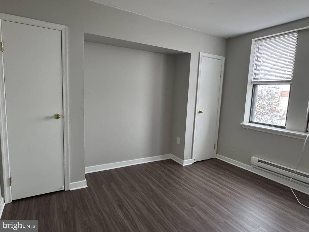 4715 Walnut Street, Unit 101 Philadelphia, PA 19139 - Photo 2 of 5 an empty room with wooden floor and windows