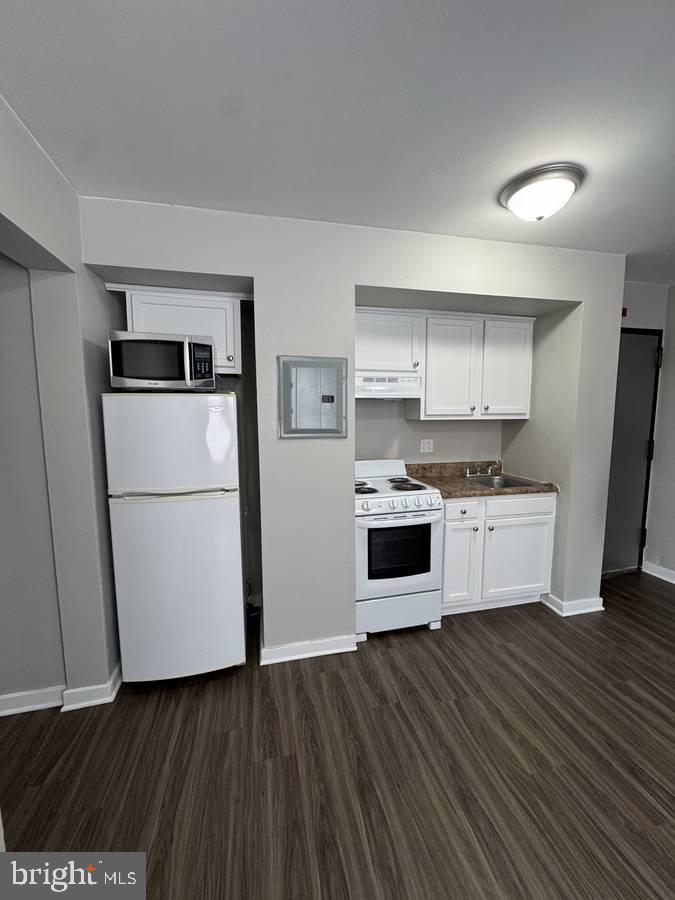 4715 Walnut Street, Unit 101 Philadelphia, PA 19139 - Photo 3 of 5 a kitchen with wooden floors and white appliances