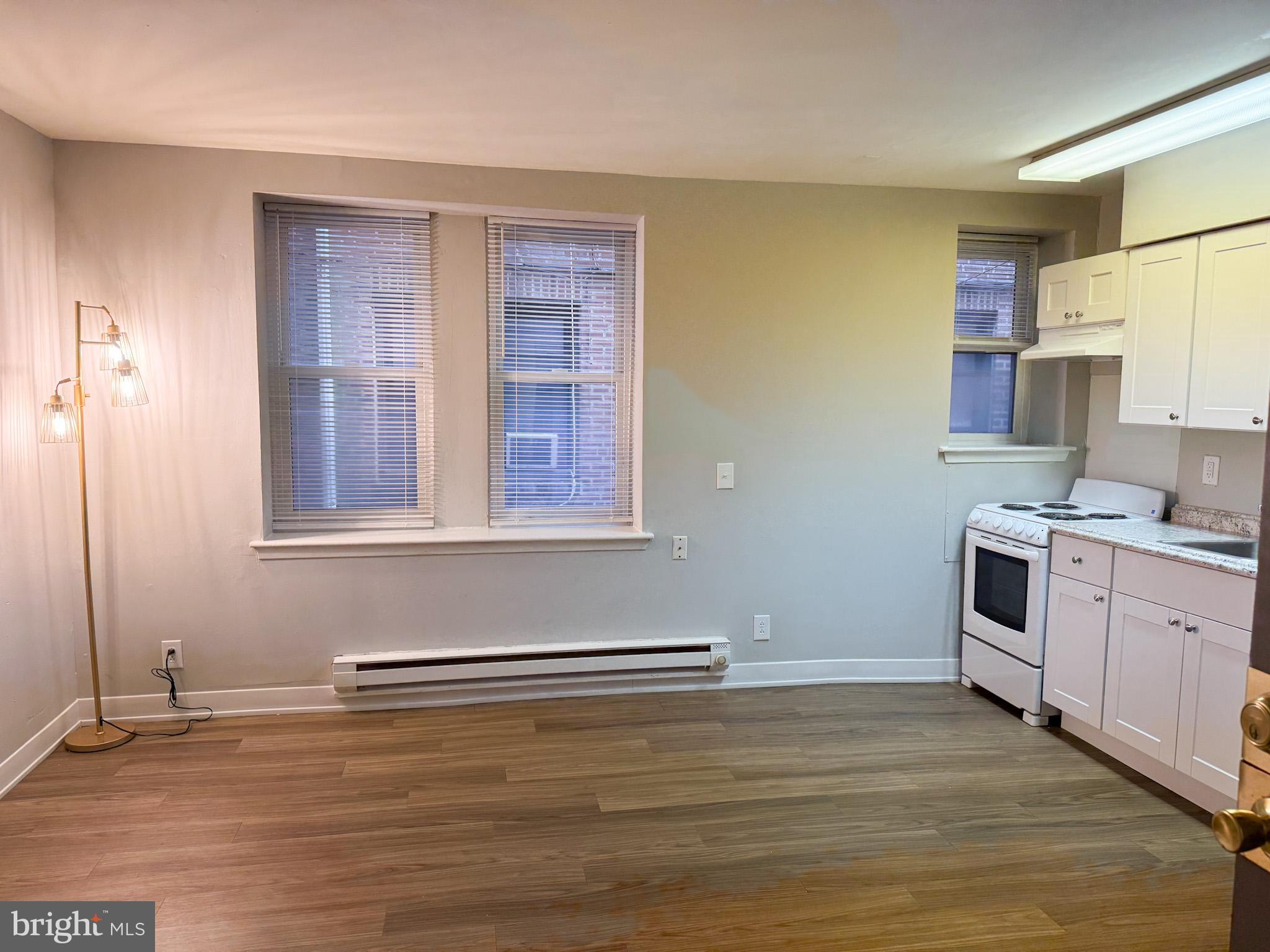 4715 Walnut Street, Unit 122 Philadelphia, PA 19139 - Photo 4 of 5 a view of a kitchen with wooden floor and electronic appliances
