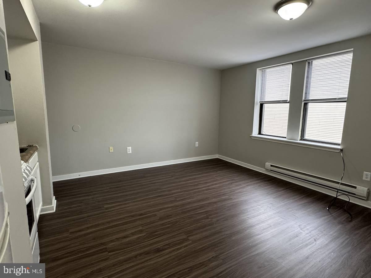4715 Walnut Street, Unit 101 Philadelphia, PA 19139 - Photo 5 of 5 an empty room with wooden floor and windows