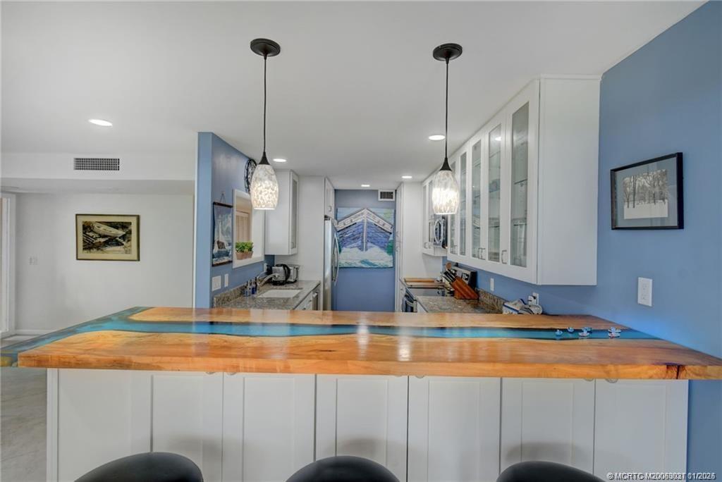 248 Northeast Edgewater Drive Stuart, FL 34996 - Photo 11 of 38 a kitchen with stainless steel appliances granite countertop sink and a refrigerator