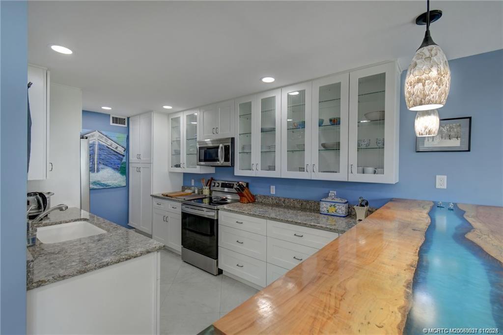 248 Northeast Edgewater Drive Stuart, FL 34996 - Photo 12 of 38 a kitchen with stainless steel appliances granite countertop a sink stove and refrigerator